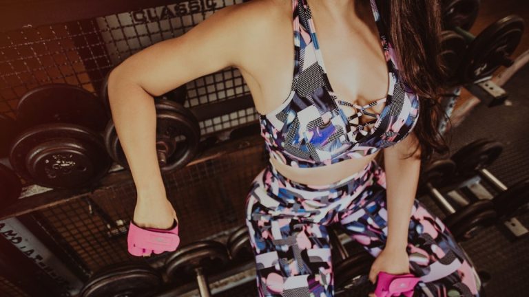 woman sitting on dumbbells on rack
