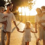 Family walking on path with trees at sunset
