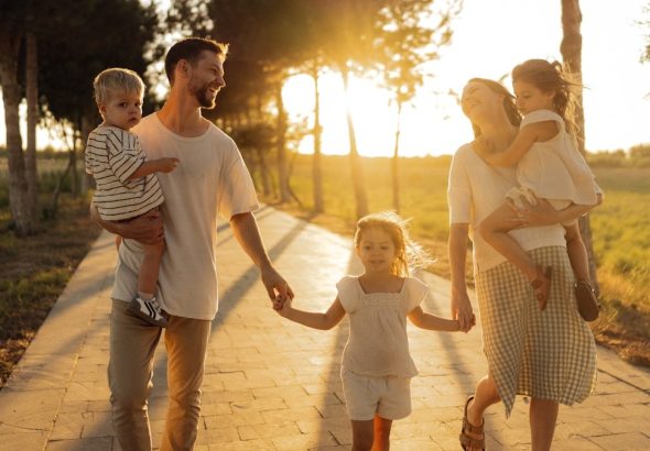 Family walking on path with trees at sunset